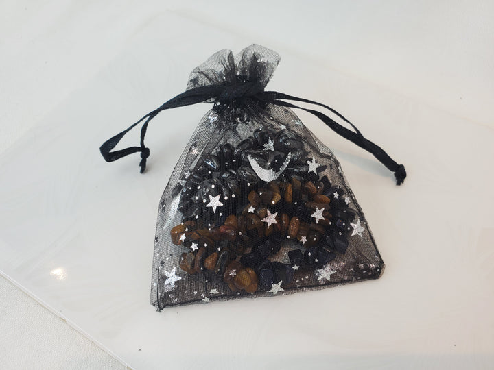 A close black organza bag, featuring a printed stars design with bracelets inside.