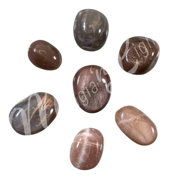 Collection of polished tumbled stones in shades of gray and brown, arranged in a circular pile.