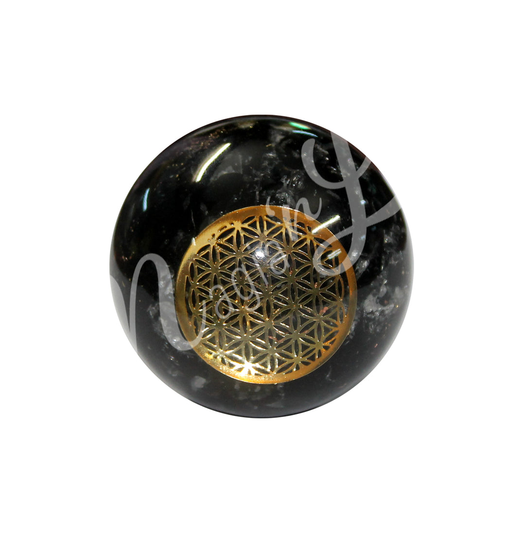 A black tourmaline in orgone sphere with a flower of life design.