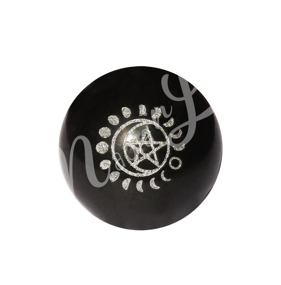 A black tourmaline sphere, engraved with a moon cycle surrounding a pentacle and a crescent moon, both painted in silver.