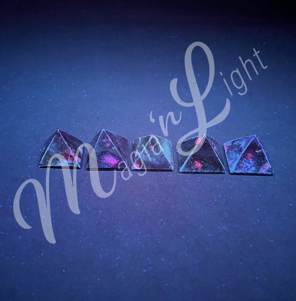 Five pyramid made of Ruby Zoisite, seen under UV light.