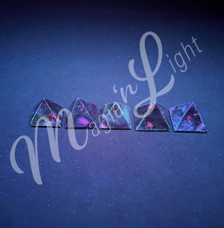 Five pyramid made of Ruby Zoisite, seen under UV light.