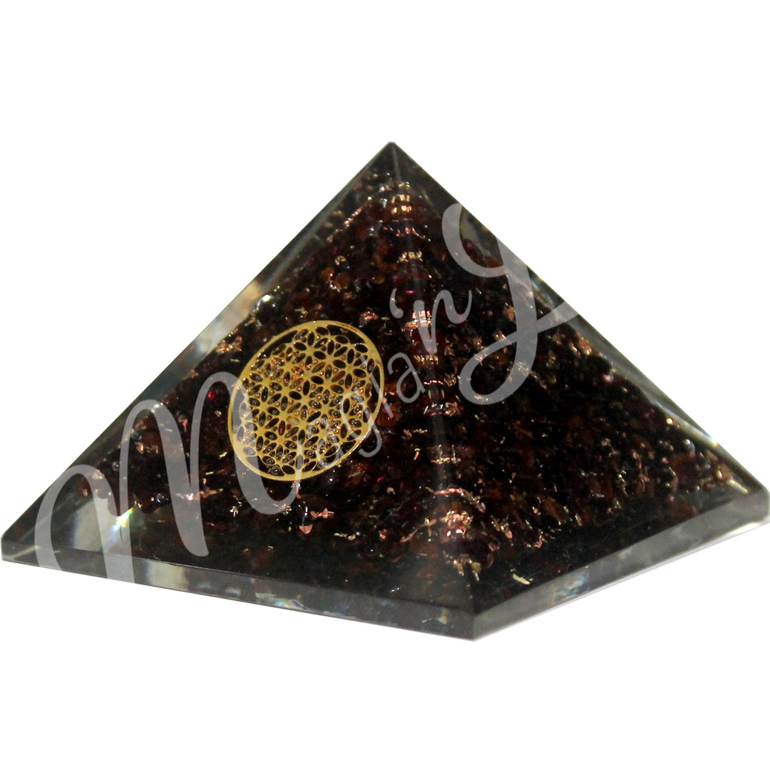 A four side pyramid made of Garnet in Orgone, featuring the flower of life symbol on one side.