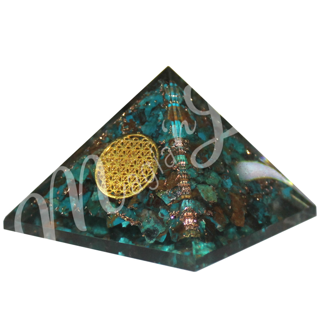 A four side pyramid made of Chrysocolla in Orgone, featuring the flower of life symbol on one side.