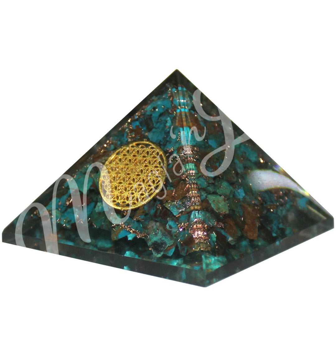 A four side pyramid made of Chrysocolla in Orgone, featuring the flower of life symbol on one side.