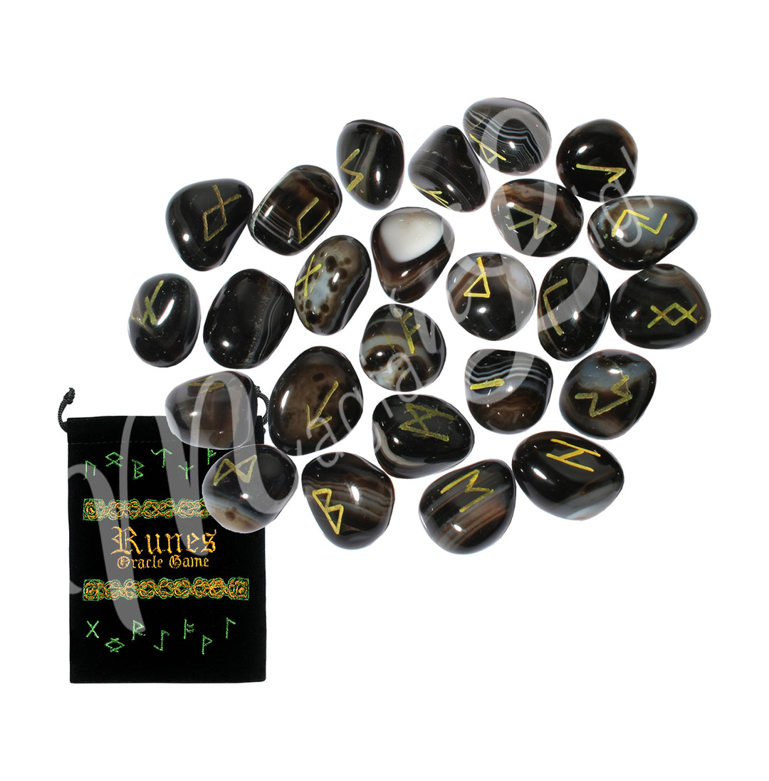 A set of black onyx runestones with engraved and painted gold symbols, displayed with a black velvet pouch. The pouch is embroidered with the words "runes oracle game", as well as runic symbols.