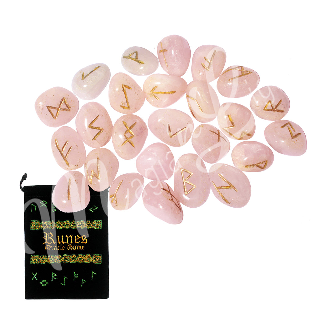 A set of rose quartz runestones with engraved and painted gold symbols, displayed with a black velvet pouch. The pouch is embroidered with the words "runes oracle game", as well as runic symbols.