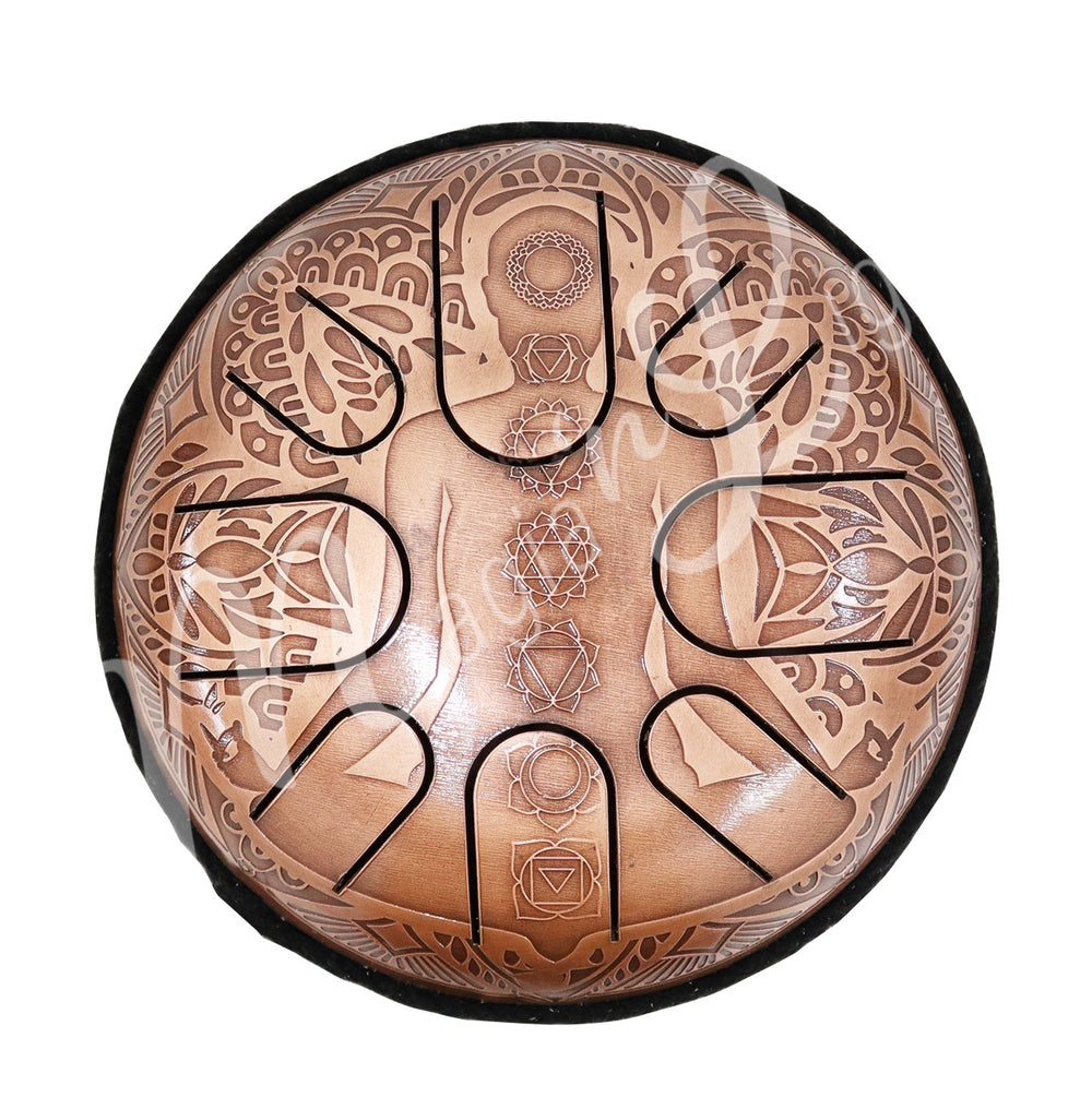 A top view of an iron tongue drum with a speckled finish, featuring multiple U-shaped cutout tongues and a chakra design