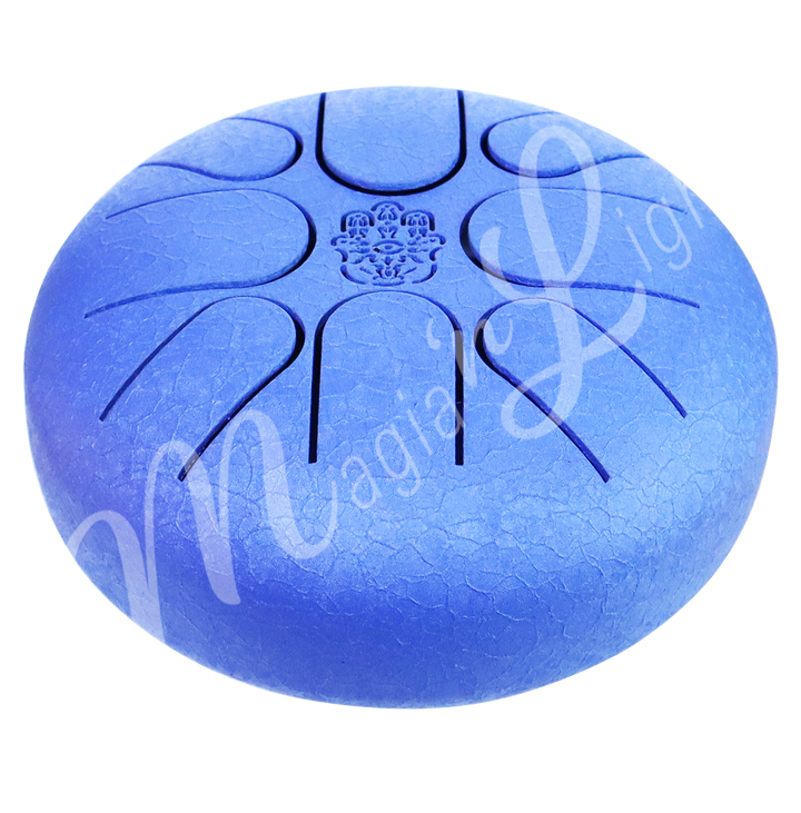A blue iron tongue drum with a speckled finish, featuring multiple U-shaped cutout tongues and a hand of fatima symbol in the center. Seen with an angle.