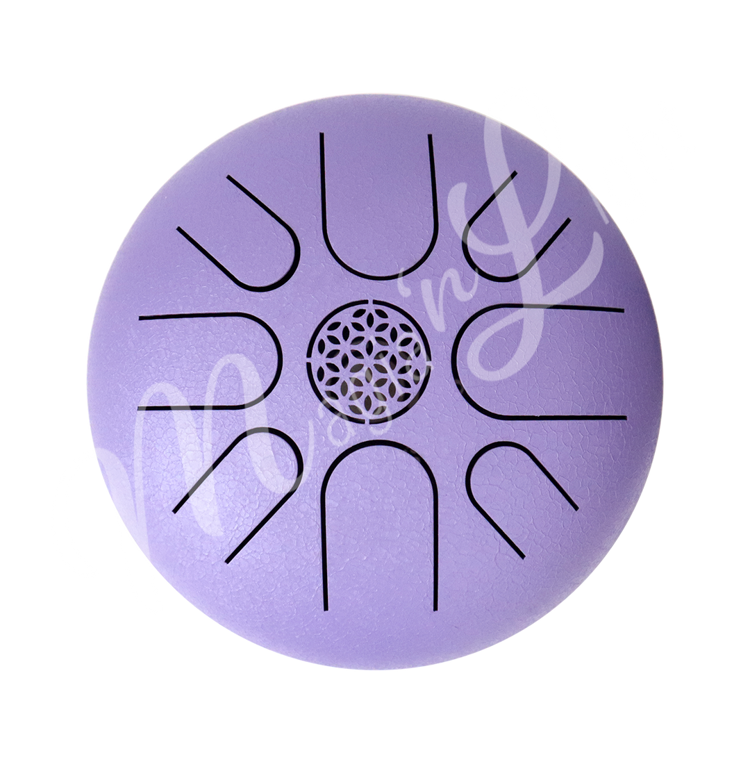 A top view of a purple iron tongue drum with a speckled finish, featuring multiple U-shaped cutout tongues and a flowerof life symbol in the center.