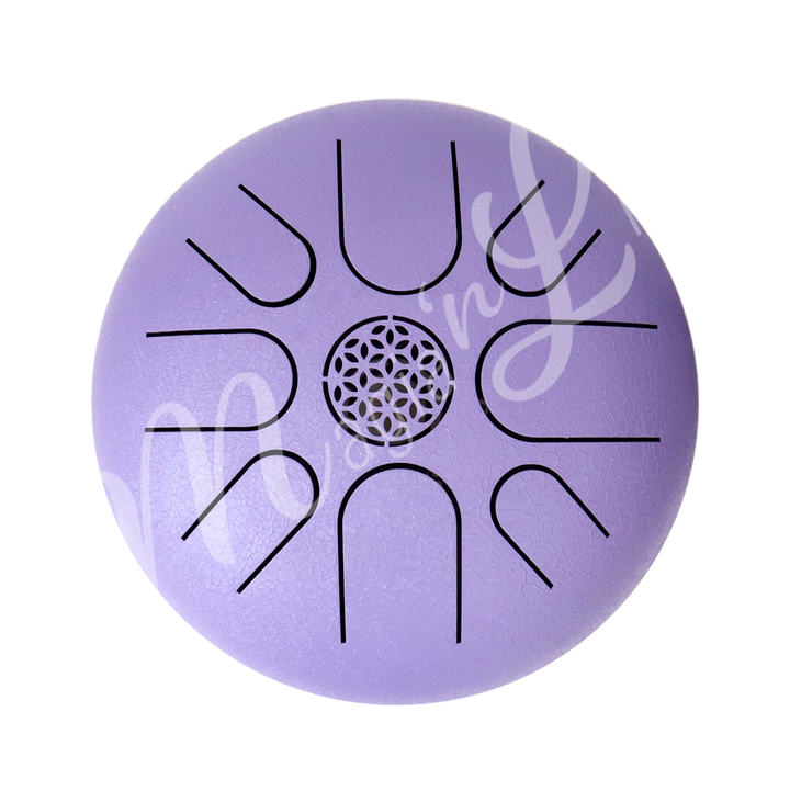 A top view of a purple iron tongue drum with a speckled finish, featuring multiple U-shaped cutout tongues and a flowerof life symbol in the center.