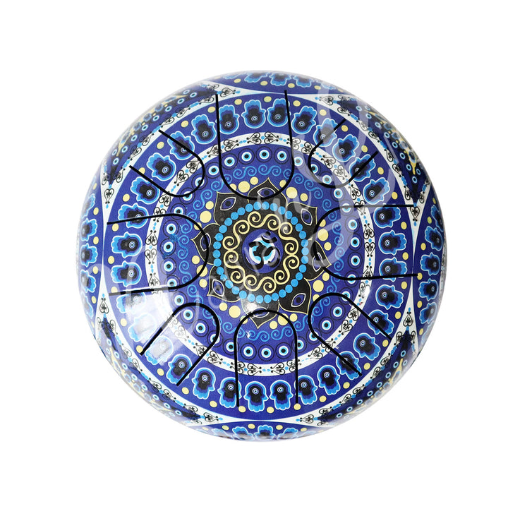 A top view of an iron tongue drum with a speckled finish, featuring multiple U-shaped cutout tongues and the hand of fatima with evil eye design.