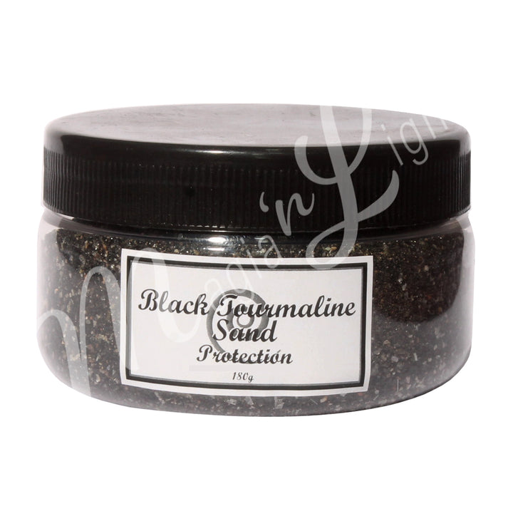 Clear plastic jar with a black lid containing black stone sand. The label reads “Black Tourmaline Sand – Protection, 180 g.”