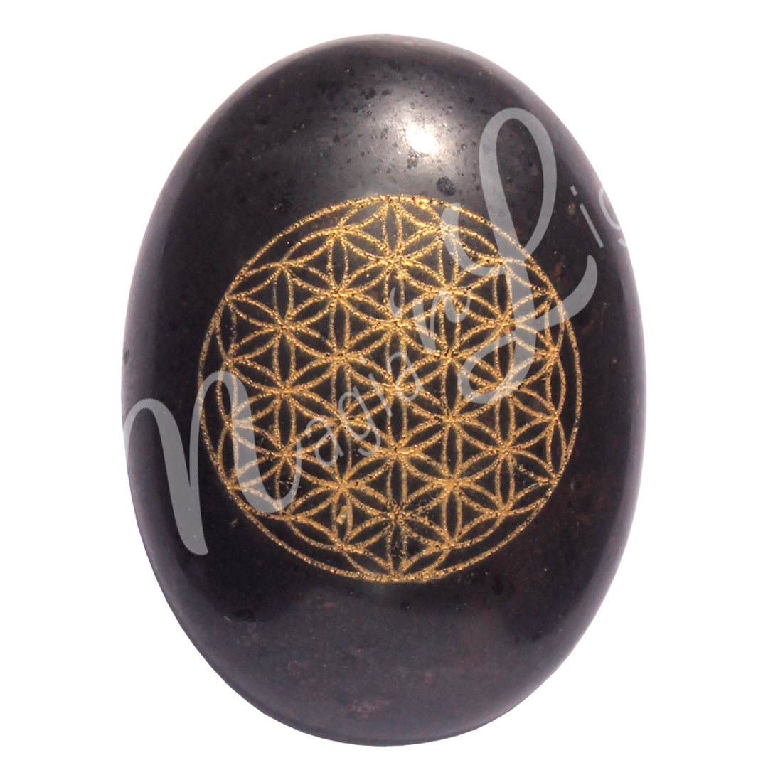 Polished Black Tourmaline palm stone engraved with a flower of life design in gold color.