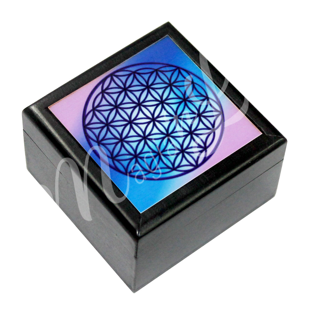 A printed black box features a Flower of Life symbol in blue and pink colors.