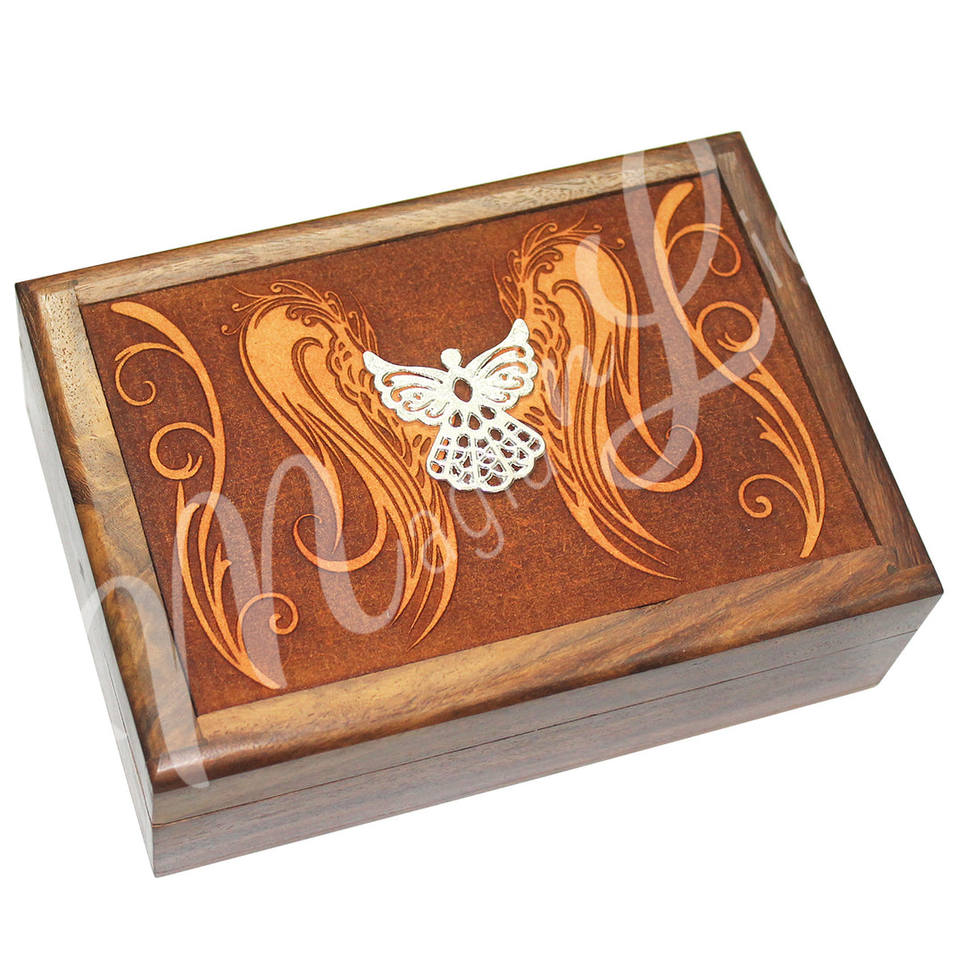 A wooden box features an angel wings design on the lid, with a metal angel charm affixed on top.
