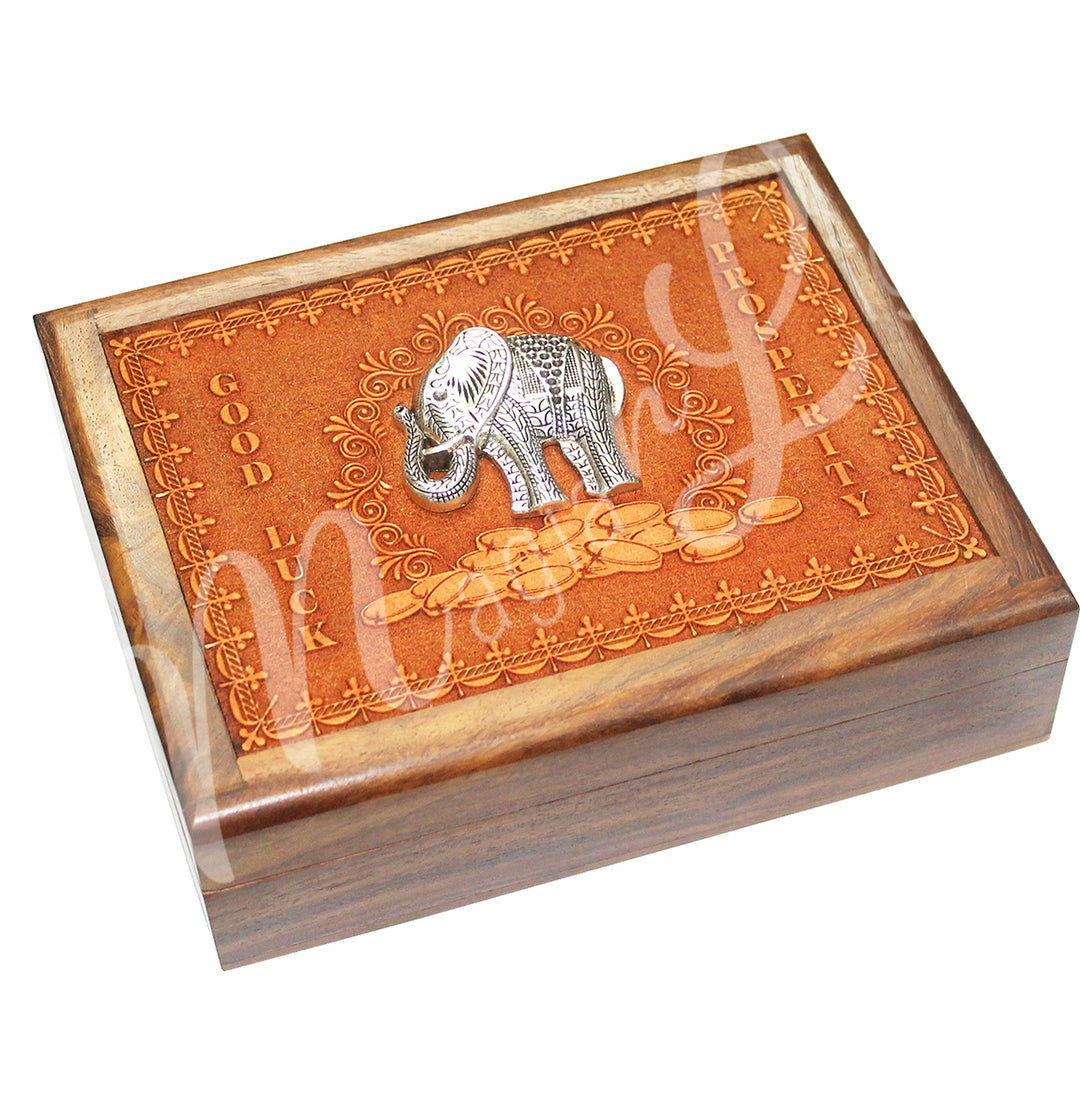 A wooden box features an elephant on the lid. The words 'GOOD LUCK' and 'PROSPERITY' are written on both sides of the lid.
