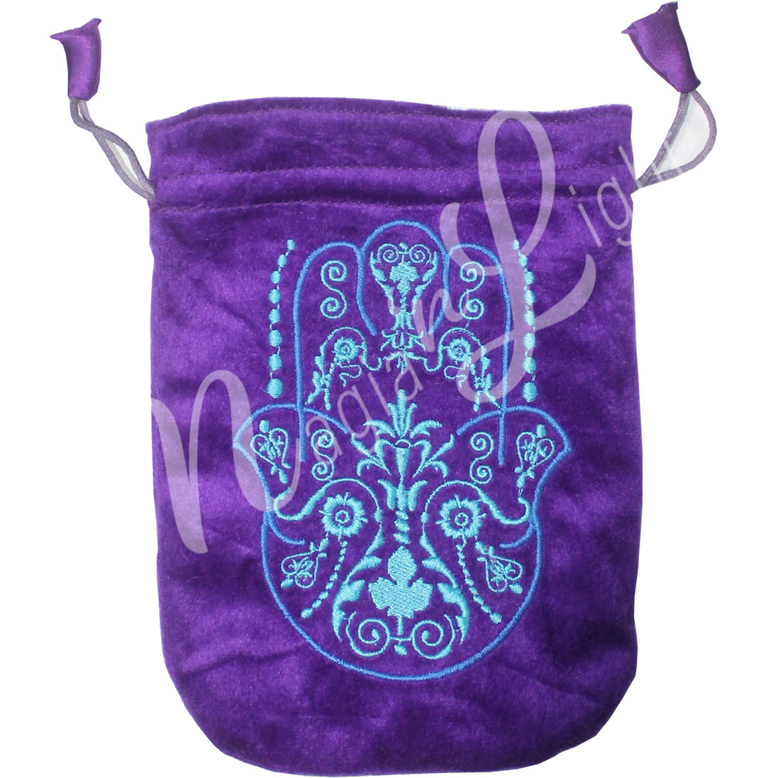 A purple bag featuring an embroidered of a blue Hand of Fatima.