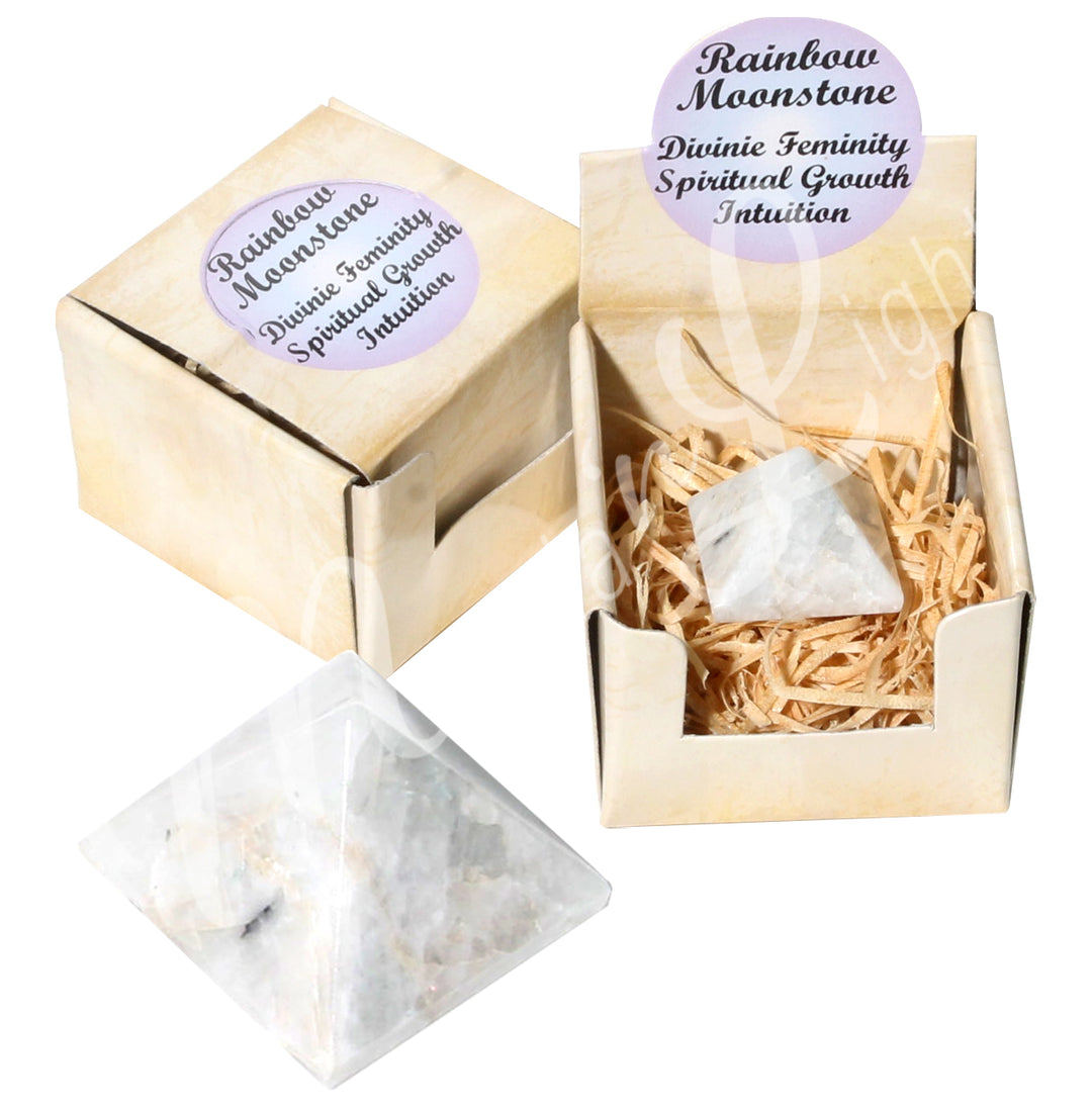 A closed gift box with the words "Rainbow Moonstone, Divine Feminity, Spiritual Grouwth, Intuition" on it;
an open gift box showing a pyramid stone with the same inscription on top, and the Rainbow Moonstone pyramid at the bottom.