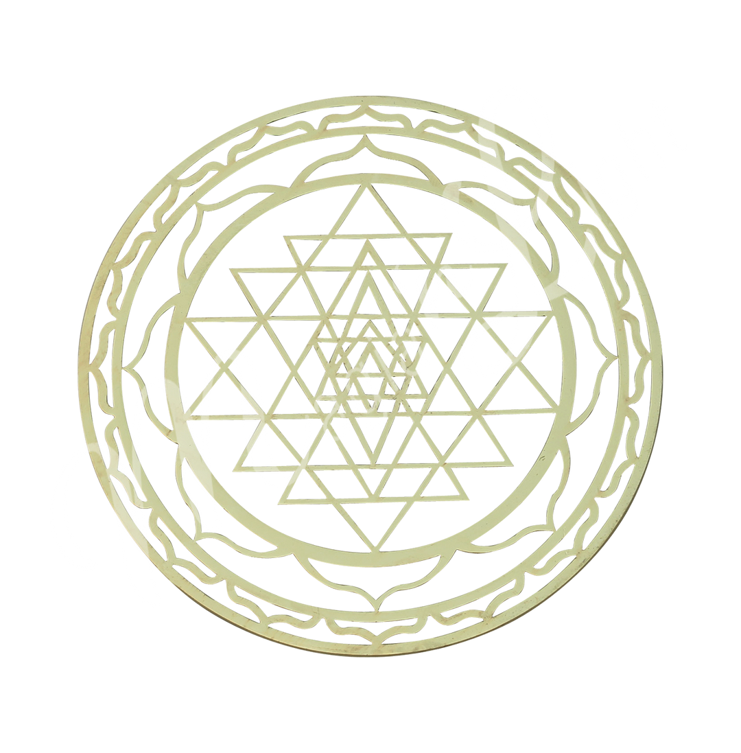An empty brass crystal grid board with Sri Yantra design.