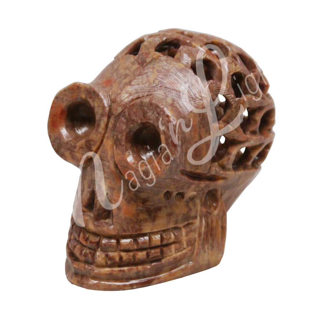 A polished skull carving made of soapstone hollow, featuring holes in the skull.