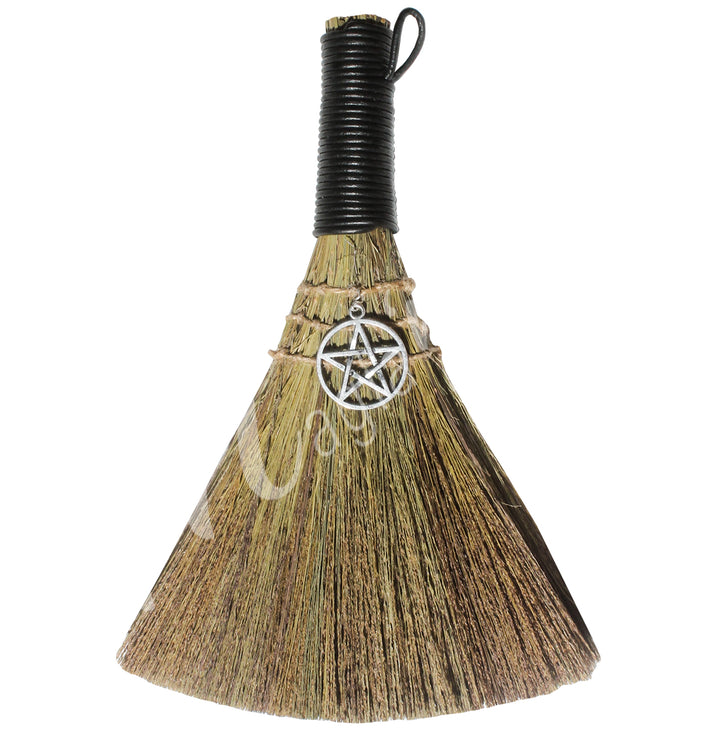 A witch's broom with a black leather cord on top and a pentacle symbol on the straw head.
