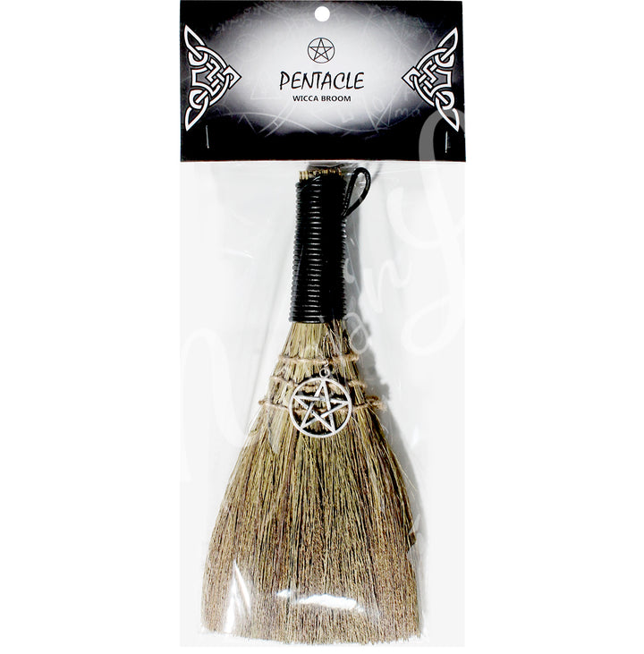 A witch's broom with a black leather cord on top and a pentacle symbol on the straw head. in a retail bag with the words: Pentace, wicca broom; on the card.