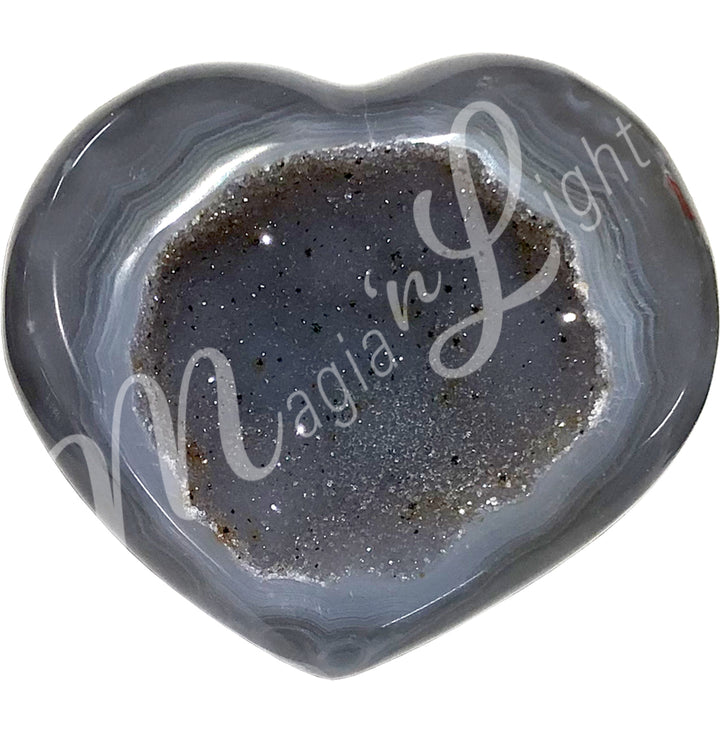 Heart-shaped grey agate with a sparkling druzy crystal center and banded patterns along the edges.