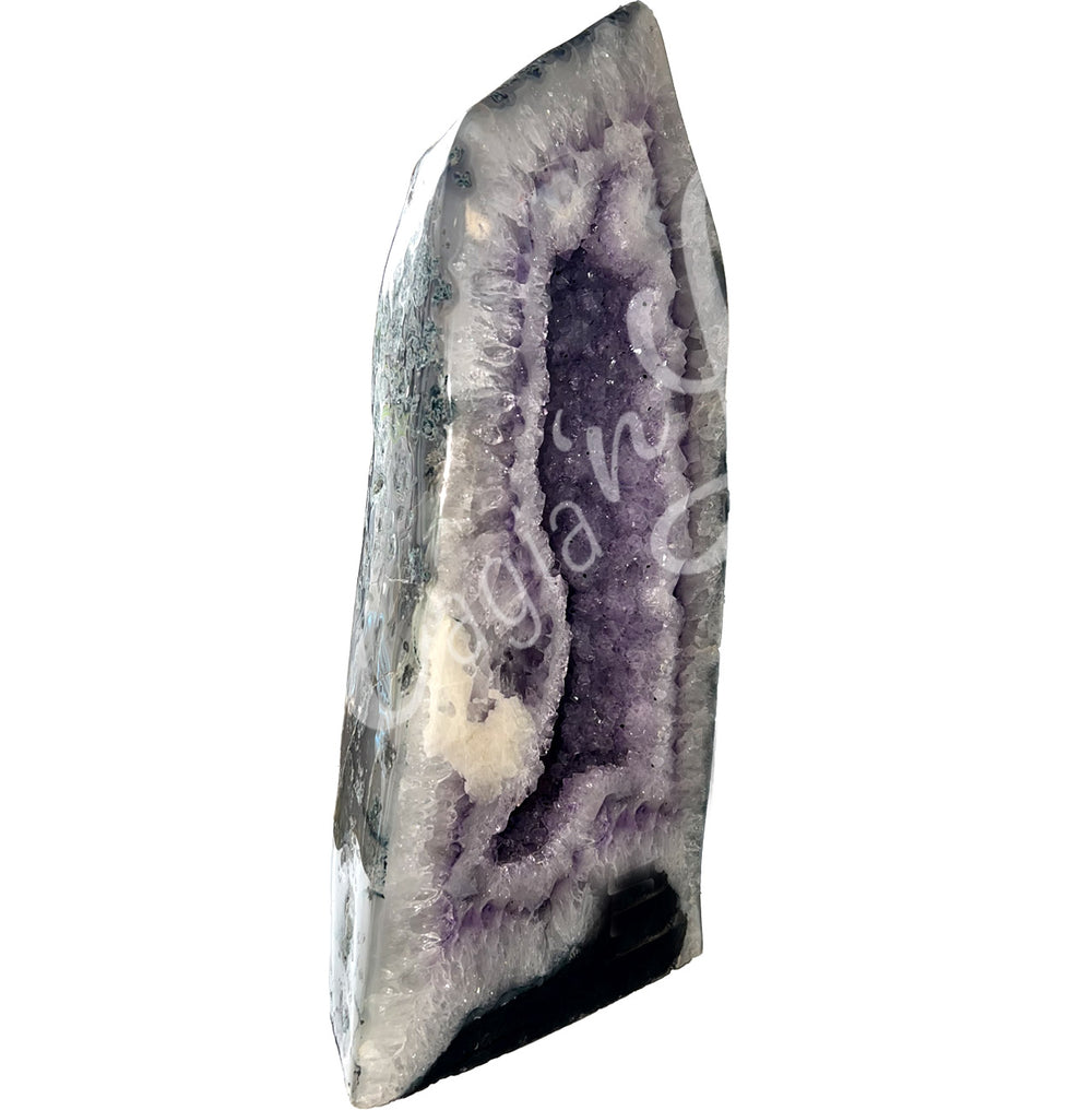 Side view of a long amethyst cathedral. The center is purple with glitter while the sides go from white to black on the exterior.
