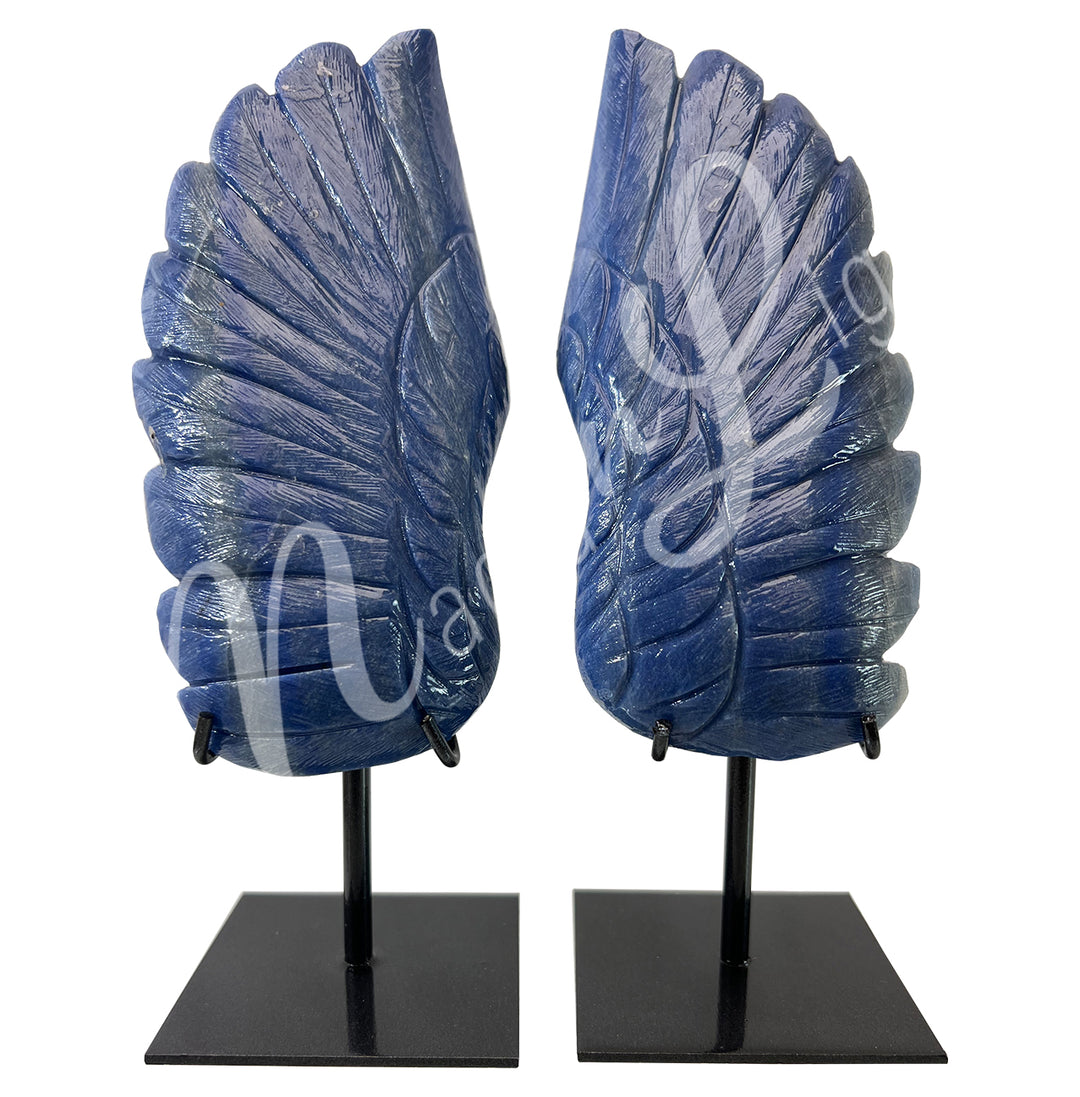 Pair of carved blue quartz angel wings displayed upright on black metal stands.