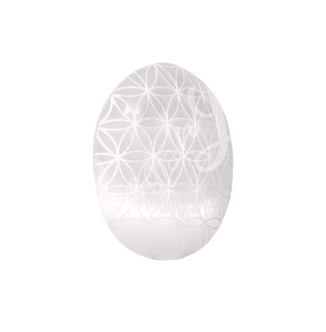 Polished Selenite palm stone engraved with a flower of life design.
