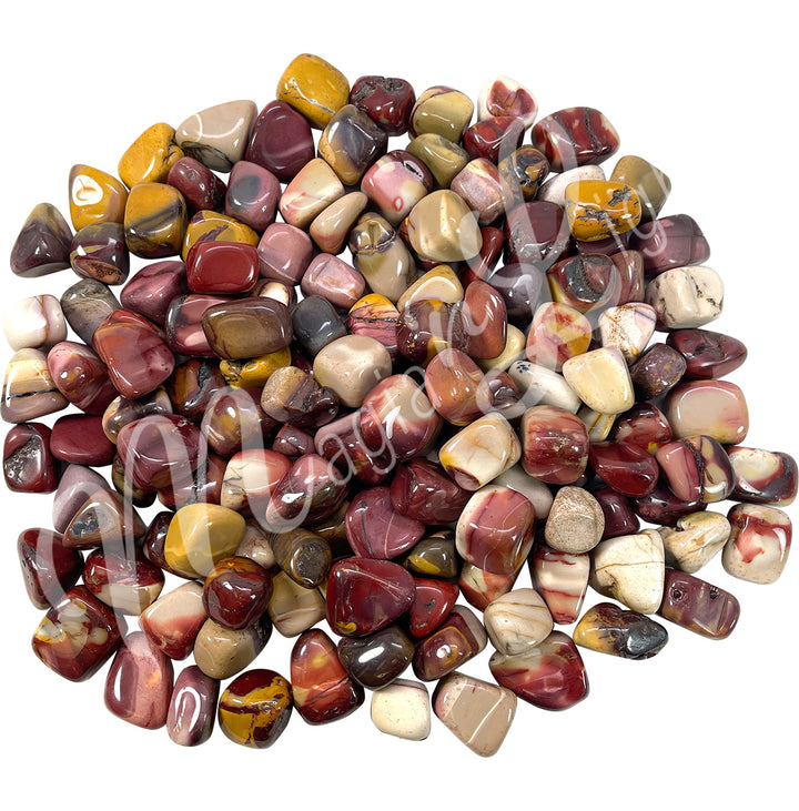 Collection of polished tumbled stones in shades of pink, yellow, brown, and cream, arranged together in a circular pile.