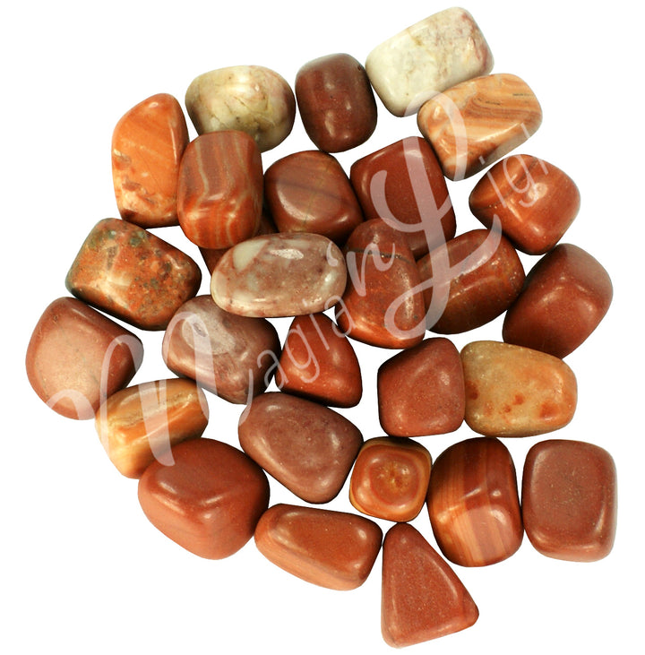 Collection of polished tumbled stones in shades of red, orange, and cream, arranged together in a circular pile.