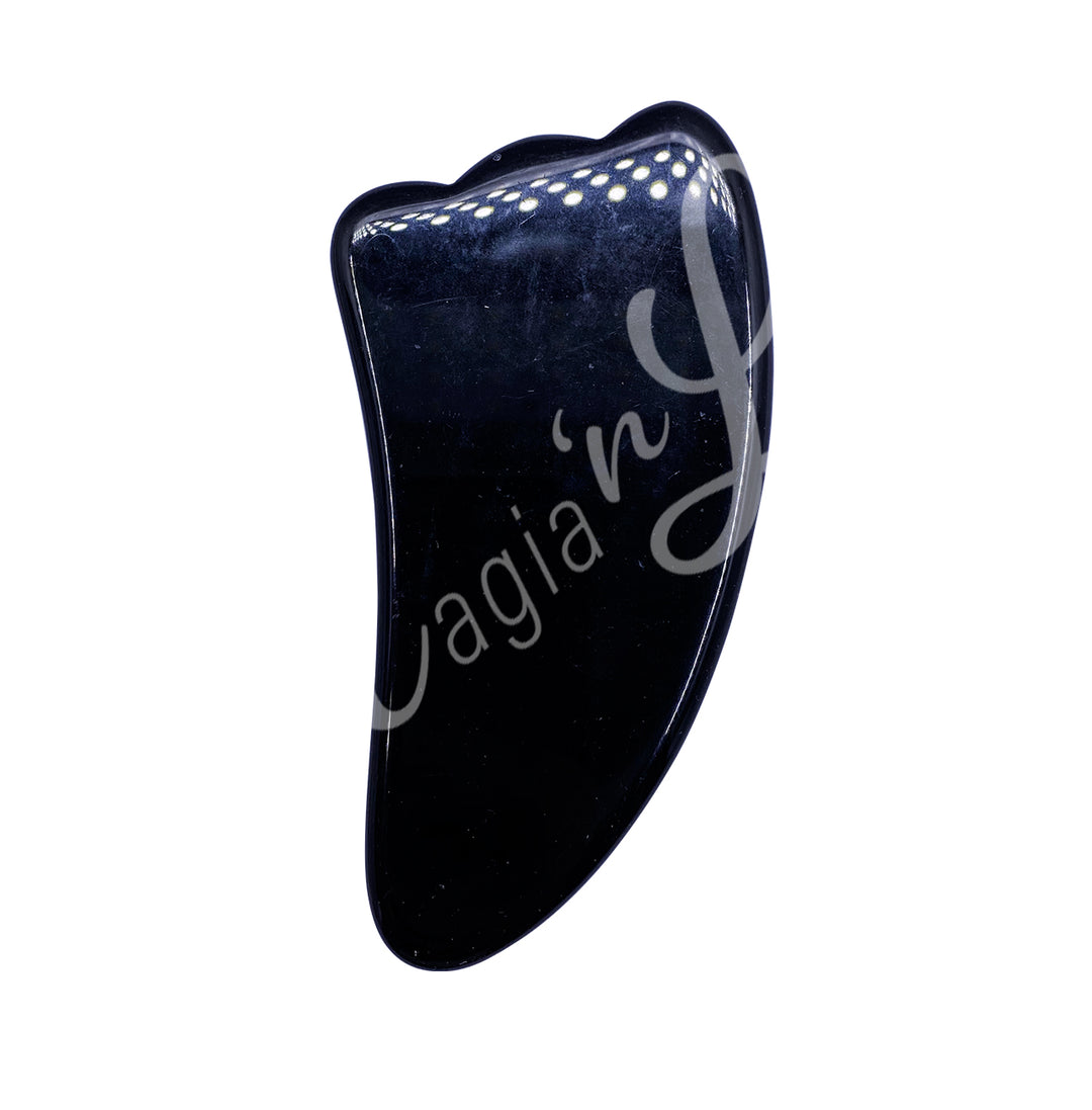 Black obsidian gua sha massage stone with a smooth curved shape and scalloped edge.