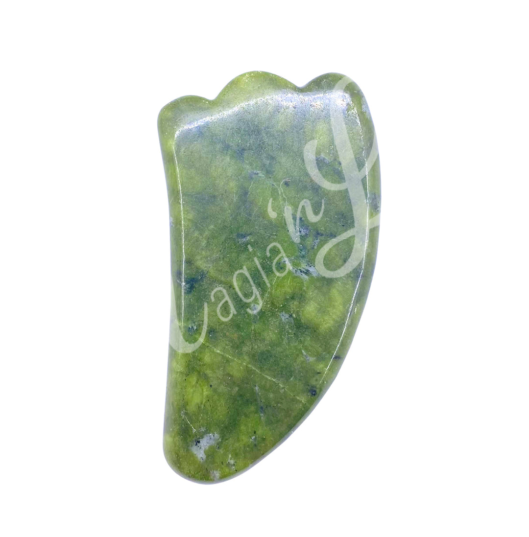 Jade gua sha massage stone with a smooth curved shape and scalloped edge.