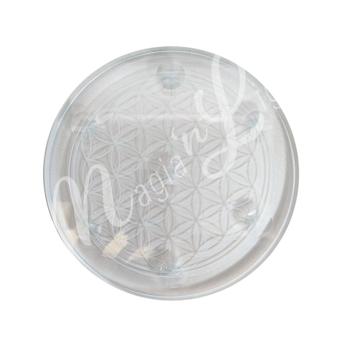 A glass plaque stand with an engraved Flower of Life.