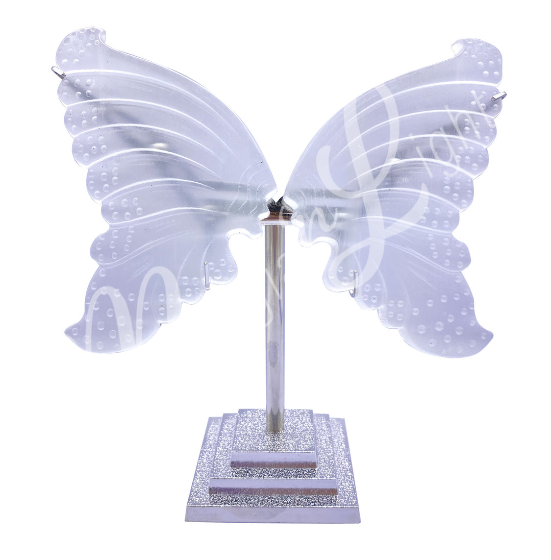Pair of carved selenite butterfly wings displayed upright on metal stands.
