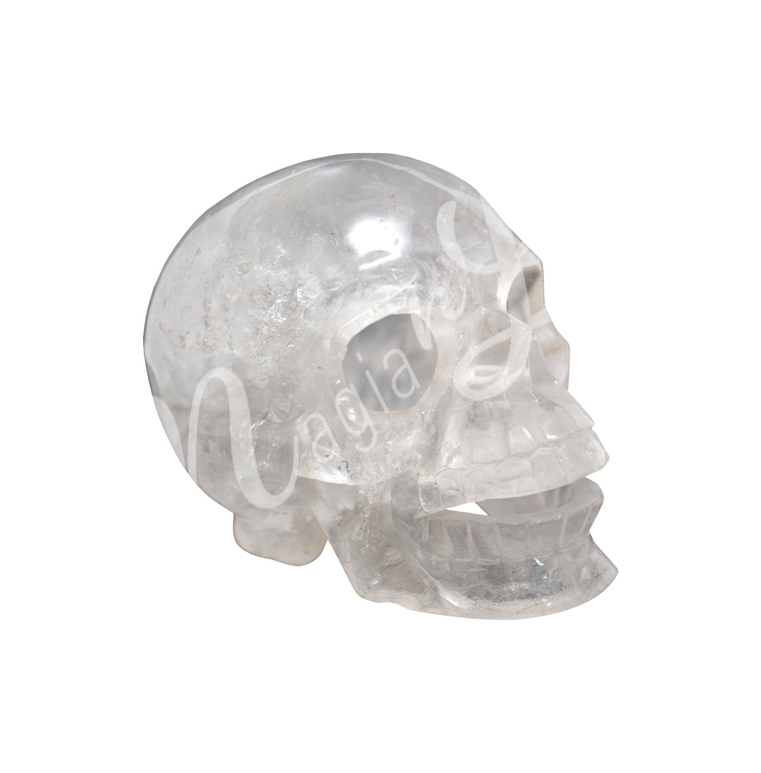 A polished skull carving made of crystal quartz hollow.