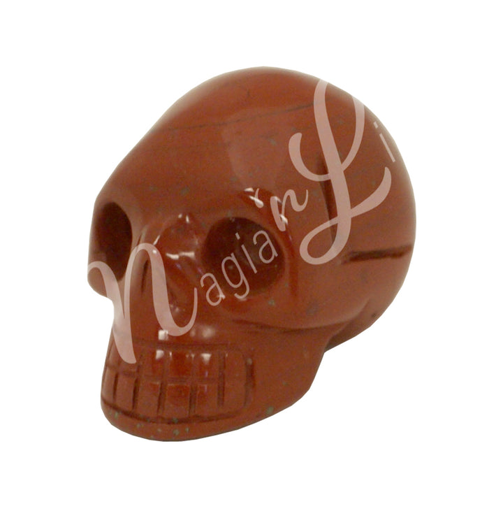 A polished skull carving made of red jasper.