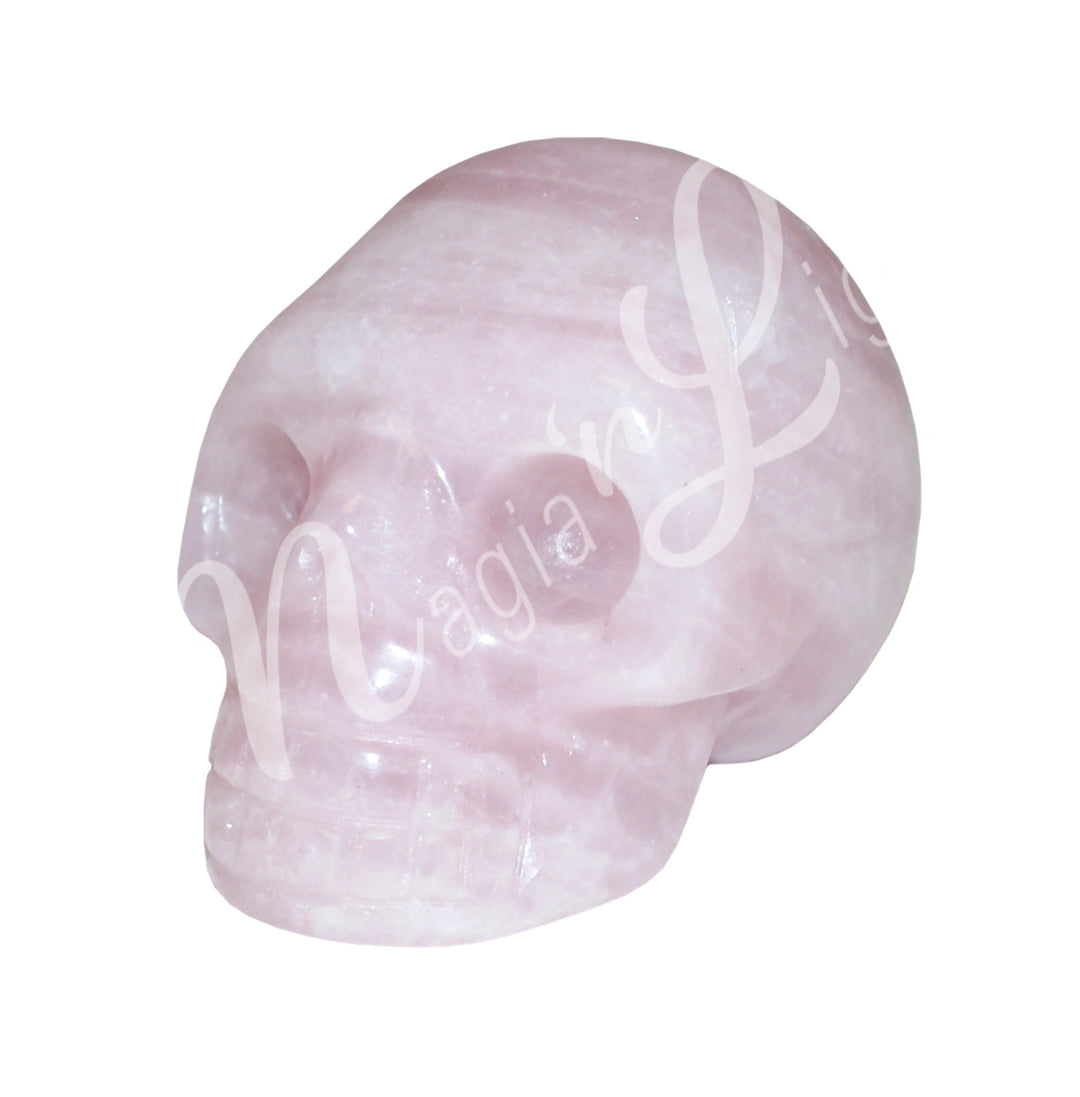 A polished skull carving made of rose quartz.
