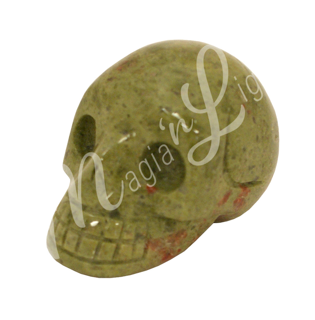 A polished skull carving made of unakite.