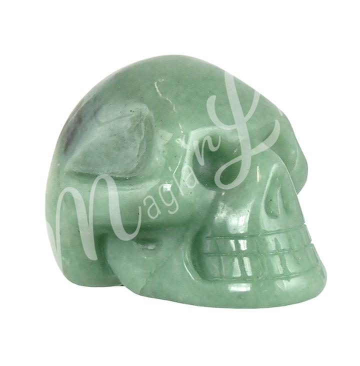 A polished skull carving made of green aventurine. Seen from the side.