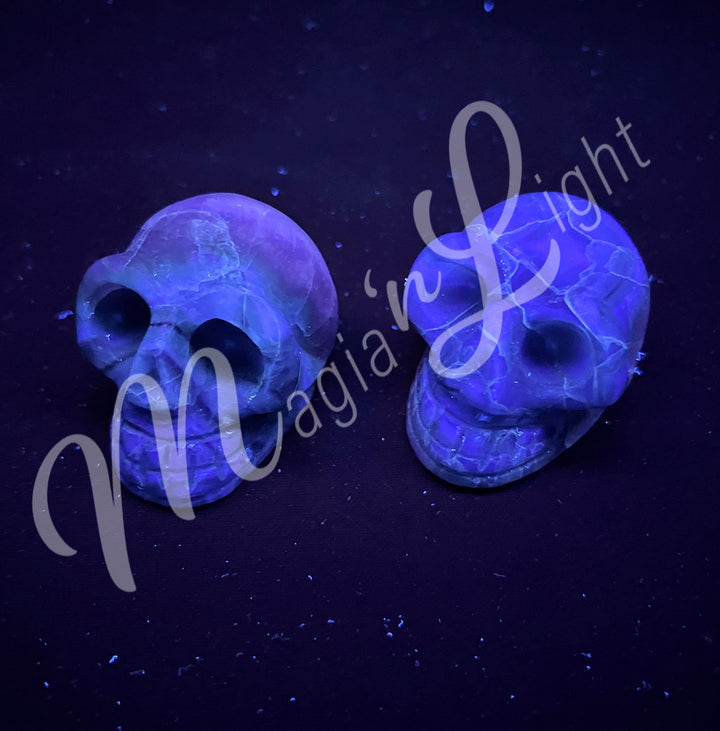 Two polished skull carving made of fluorite. Seen under UV light.