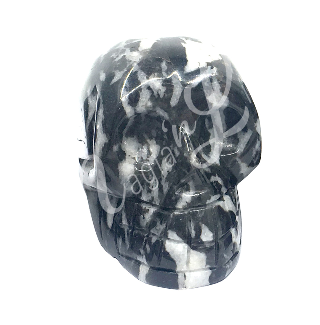 A polished skull carving made of tiger calcite.