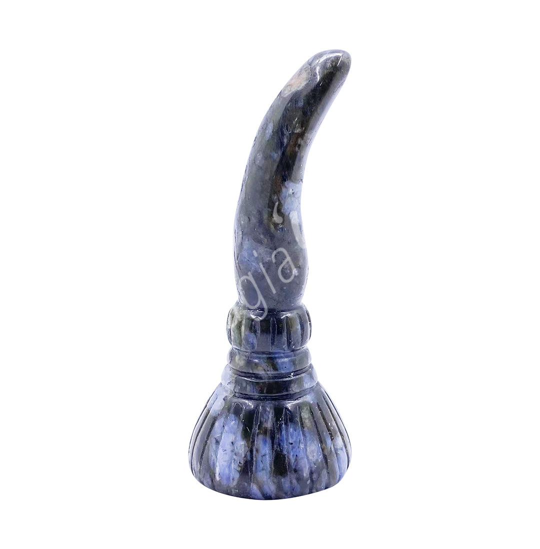 A carving of a witch's broom, made of glaucophane.