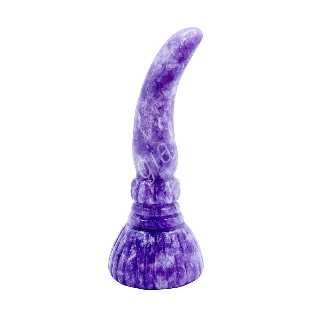 A carving of a witch's broom, made of lepidolite.
