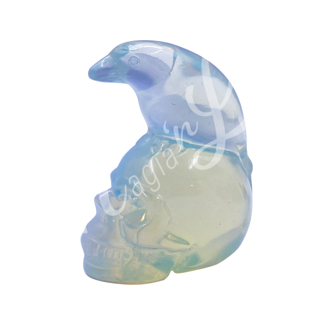 A polished raven on a skull carving made of opalite.