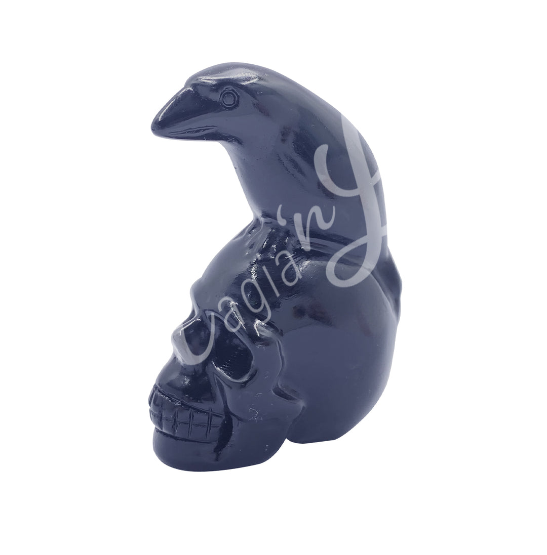A polished raven on a skull carving made of black obsidian.