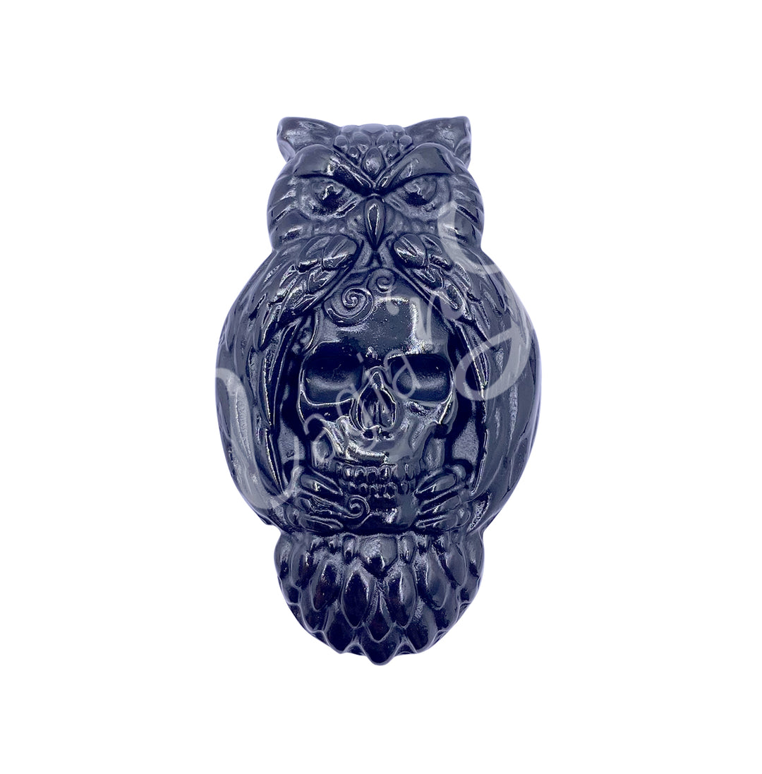 A carving of an owl with a skull to replace the belly, made of black obsidian.