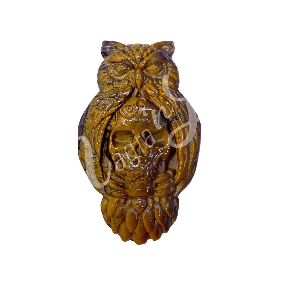 A carving of an owl with a skull to replace the belly, made of tiger eye.